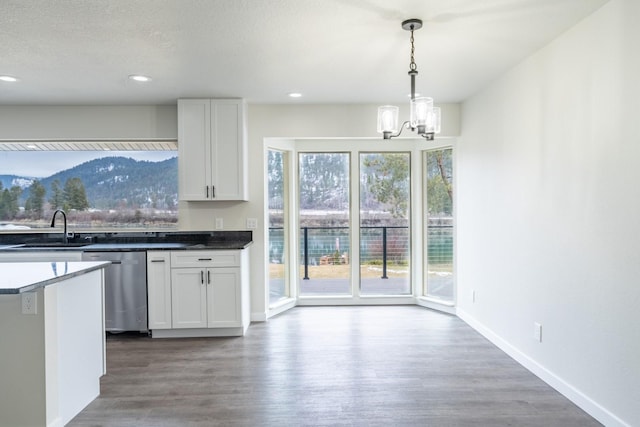 kitchen with white cabinetry, sink, hanging light fixtures, and dishwasher