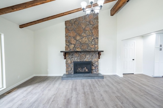 unfurnished living room featuring light hardwood / wood-style flooring, an inviting chandelier, high vaulted ceiling, a stone fireplace, and beamed ceiling