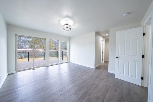 spare room with dark wood-type flooring