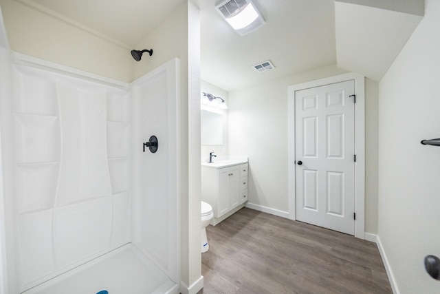 bathroom featuring vanity, toilet, hardwood / wood-style floors, and a shower