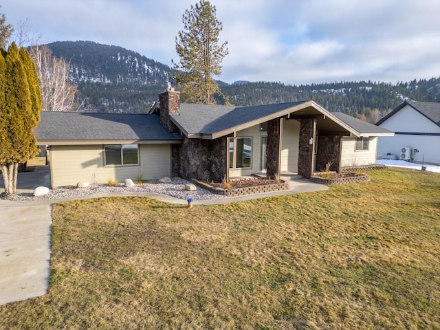 ranch-style house featuring a mountain view and a front lawn