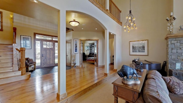 foyer with an inviting chandelier, a high ceiling, and light wood-type flooring