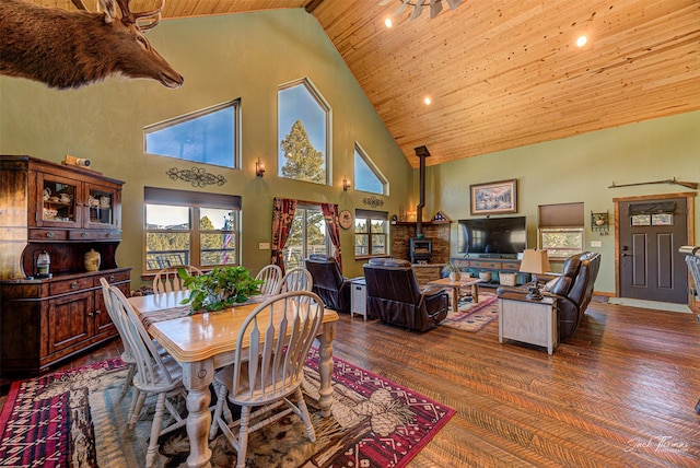 dining area with wood ceiling, lofted ceiling, dark hardwood / wood-style flooring, and a wood stove