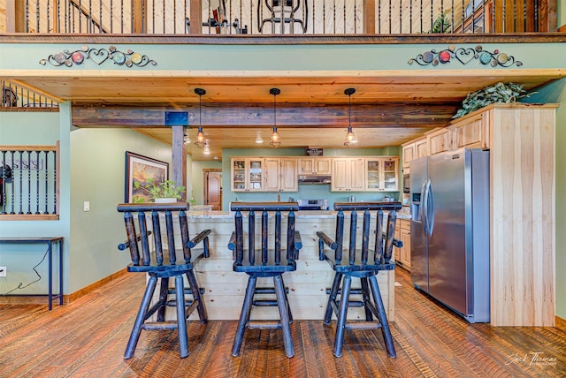 kitchen featuring pendant lighting, beam ceiling, light brown cabinets, and appliances with stainless steel finishes