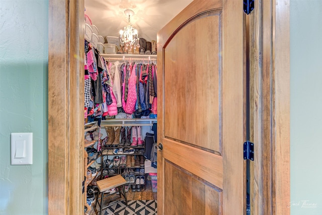 spacious closet with a notable chandelier