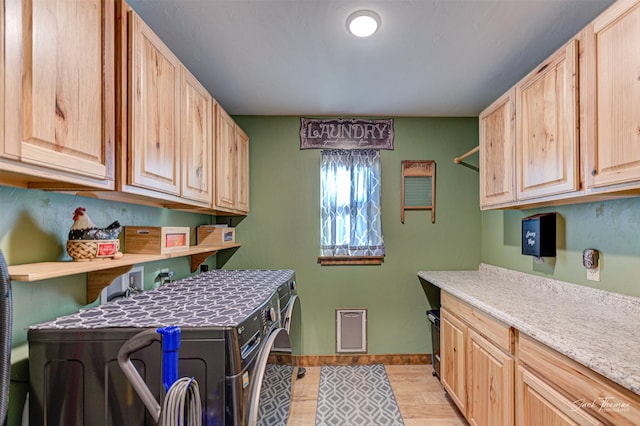 laundry room with cabinets and washing machine and clothes dryer