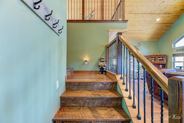 staircase featuring wood ceiling and a towering ceiling