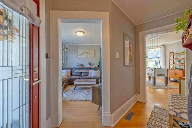 interior space featuring crown molding and light hardwood / wood-style flooring