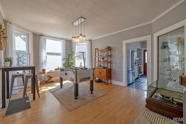 recreation room featuring hardwood / wood-style floors and crown molding