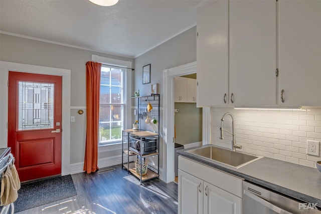 kitchen with dark hardwood / wood-style floors, white cabinetry, sink, ornamental molding, and stainless steel dishwasher