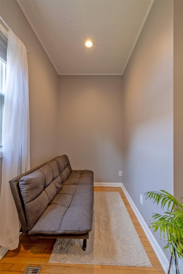 sitting room featuring ornamental molding and light hardwood / wood-style floors