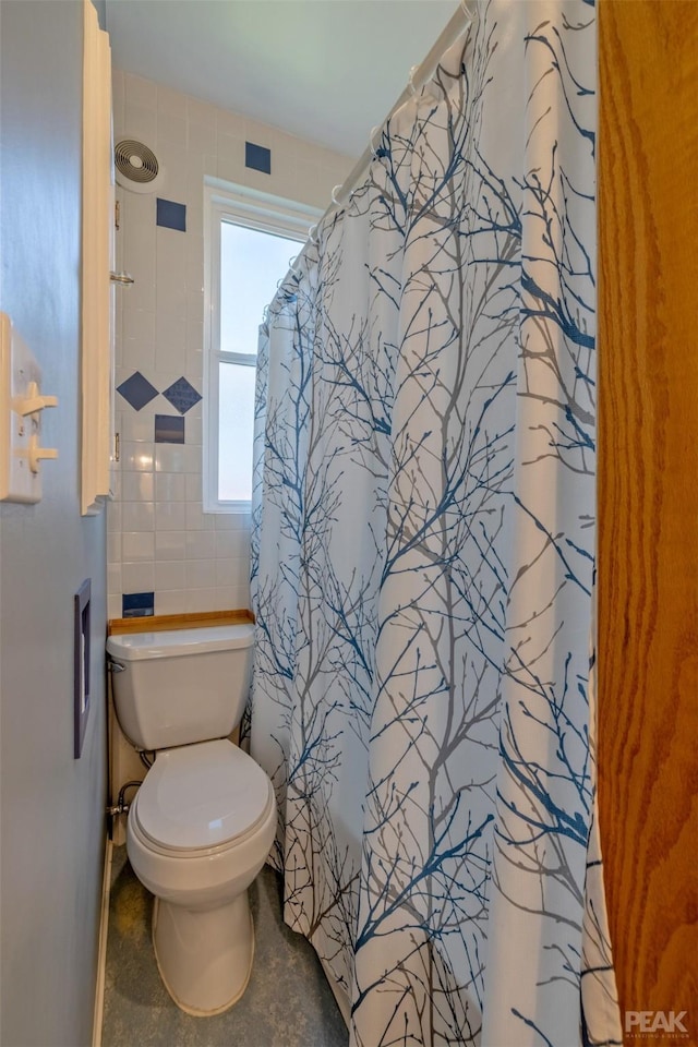 bathroom featuring walk in shower and toilet