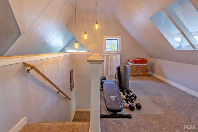 exercise room featuring carpet flooring and vaulted ceiling with skylight