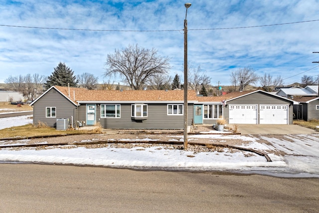 ranch-style home featuring central AC and a garage