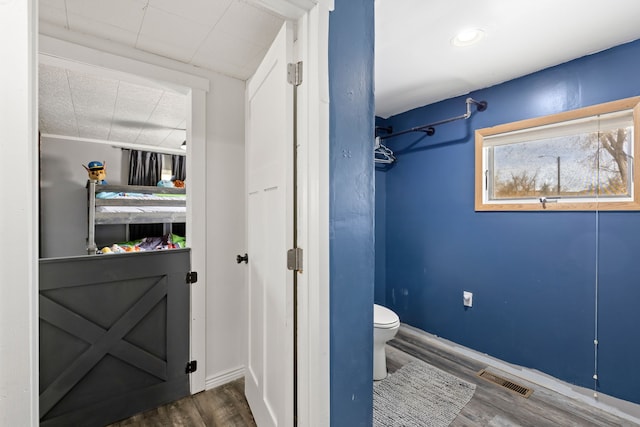 bathroom featuring hardwood / wood-style flooring and toilet