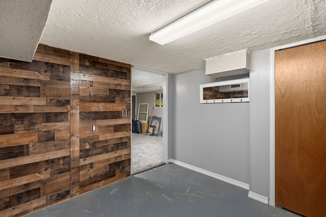 corridor with a textured ceiling and wood walls