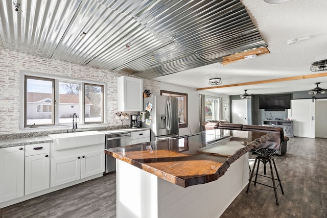 kitchen featuring white cabinetry, sink, a breakfast bar area, and appliances with stainless steel finishes