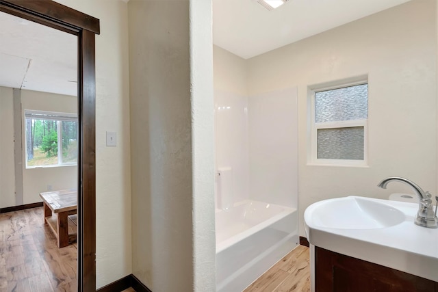 bathroom featuring hardwood / wood-style flooring, vanity, and a bathtub