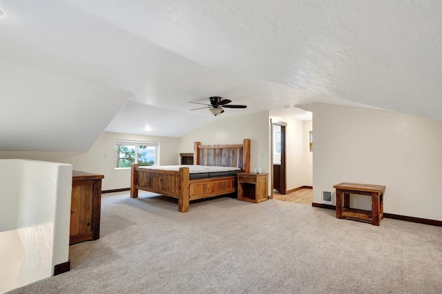 carpeted bedroom with ceiling fan, lofted ceiling, and a textured ceiling