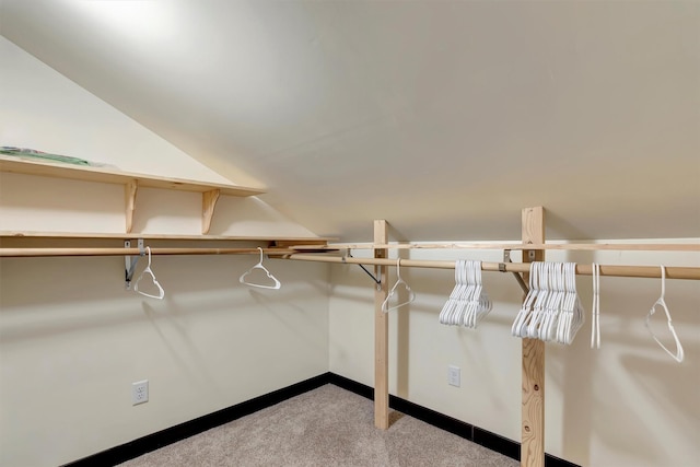 spacious closet with vaulted ceiling and light colored carpet