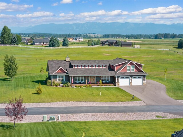 view of front of house featuring a garage, a mountain view, central AC, and a front yard