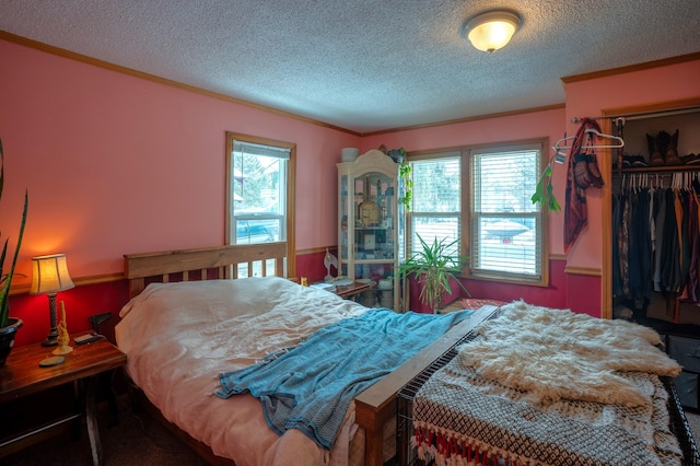 bedroom featuring crown molding, a textured ceiling, and a closet