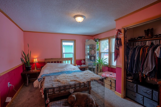 carpeted bedroom featuring crown molding, a textured ceiling, and a closet