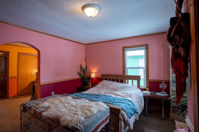 bedroom with crown molding, a textured ceiling, and carpet