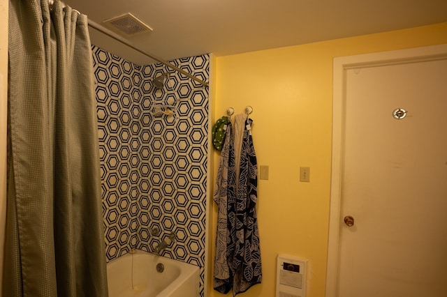 bathroom with heating unit and shower / bath combination with curtain