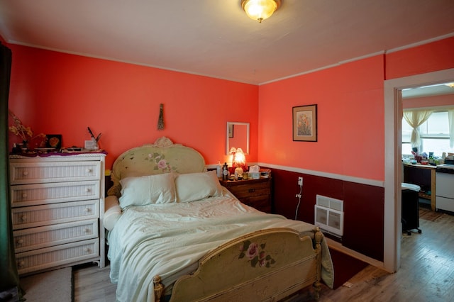 bedroom featuring wood-type flooring and heating unit