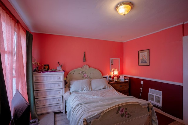 bedroom featuring hardwood / wood-style floors and heating unit