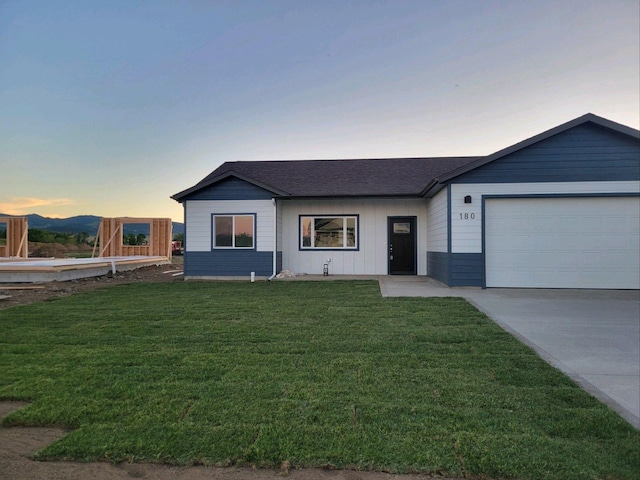 single story home with a garage and a yard