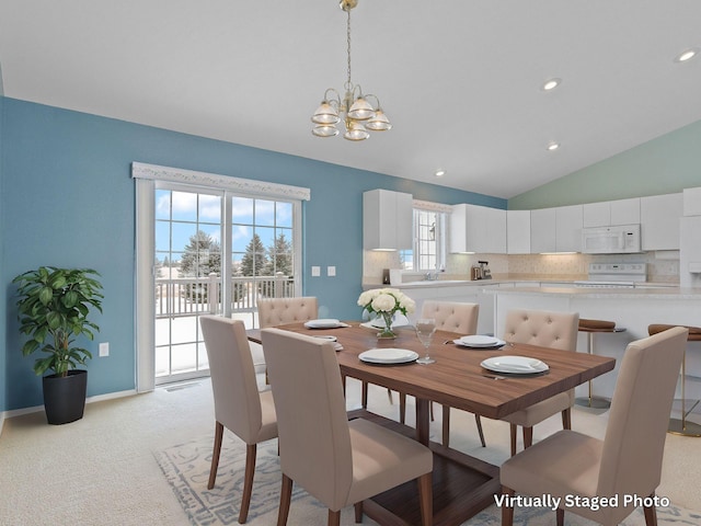 carpeted dining space with lofted ceiling, sink, and a notable chandelier