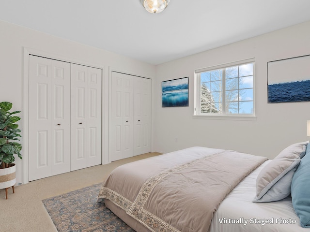 bedroom featuring carpet floors and two closets