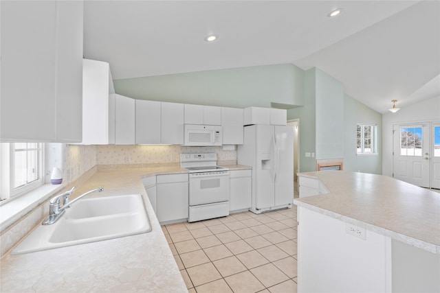 kitchen with sink, white cabinetry, vaulted ceiling, light tile patterned floors, and white appliances