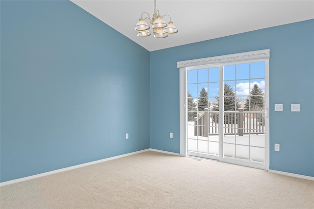 unfurnished room featuring carpet flooring, a chandelier, and vaulted ceiling