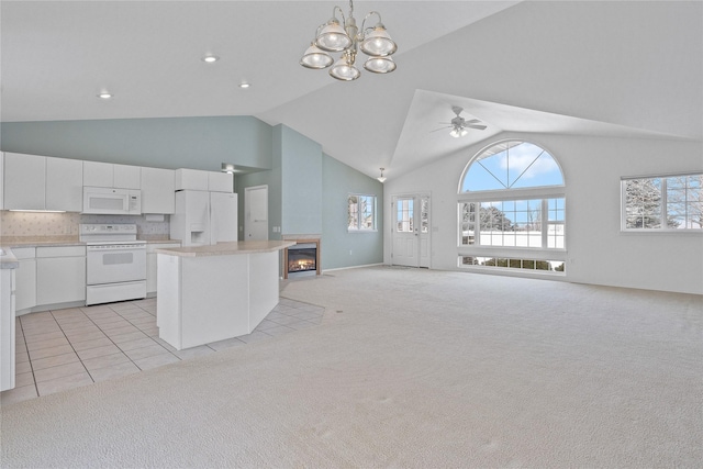 kitchen featuring white cabinetry, light carpet, white appliances, and decorative light fixtures