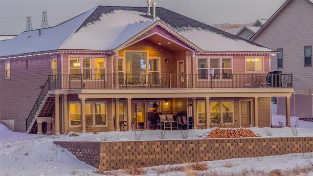 snow covered property with a balcony