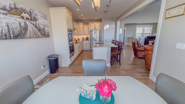 dining room with sink and light wood-type flooring