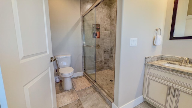 bathroom featuring vanity, toilet, and a shower with door