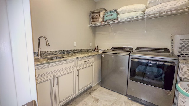 washroom with cabinets, separate washer and dryer, and sink