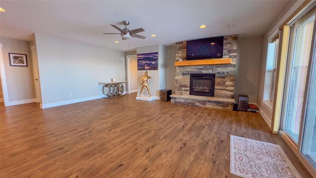 living room with ceiling fan, a fireplace, and wood-type flooring