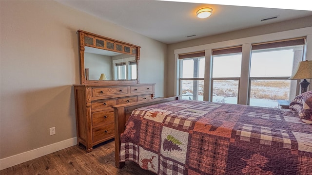 bedroom with dark hardwood / wood-style flooring