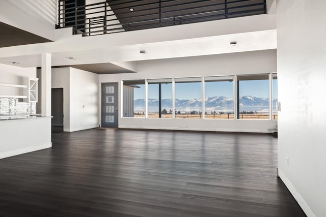 2986 Sunset Ranch Ln, Stevensville, MT 59870 - unfurnished living room with a mountain view, a towering ceiling, and dark hardwood / wood-style flooring