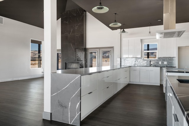 2986 Sunset Ranch Ln, Stevensville, MT 59870 - kitchen with white cabinetry, a towering ceiling, backsplash, and dark hardwood / wood-style floors