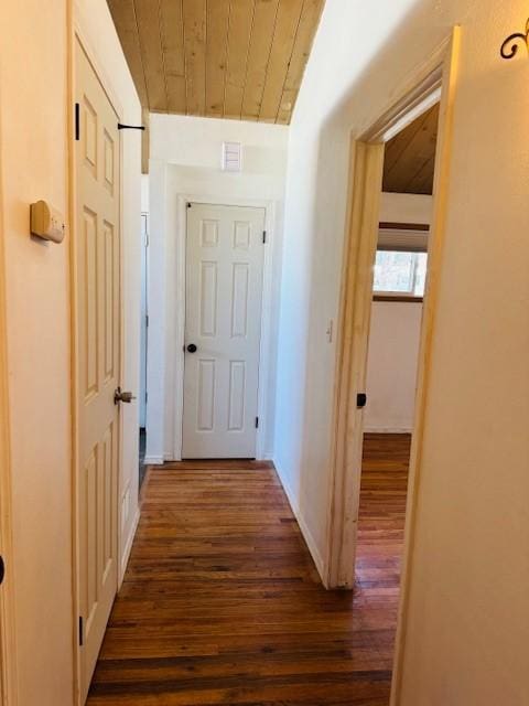 hallway featuring dark wood-type flooring and wooden ceiling