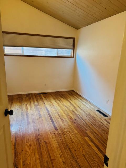 unfurnished room featuring lofted ceiling, hardwood / wood-style flooring, and wooden ceiling