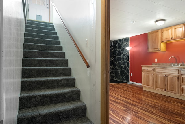 stairway with sink and hardwood / wood-style floors