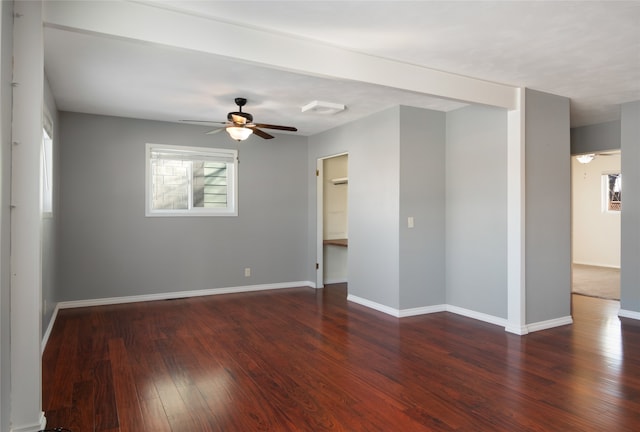 empty room featuring dark wood-type flooring and ceiling fan