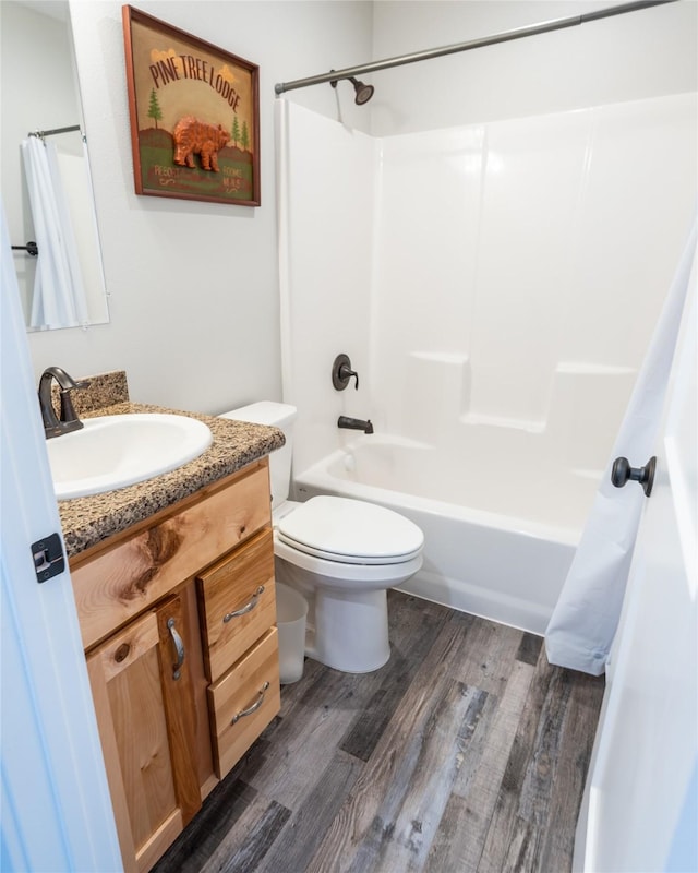 full bathroom featuring vanity, hardwood / wood-style floors, shower / bath combination with curtain, and toilet